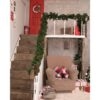 Christmas interior of the house, the staircase is decorated with branches of the Christmas tree and Christmas toys. Red door, gifts. Festive mood, joy and happiness. A little magic. New Year